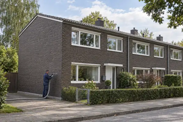 Illustration eines Reihenendhauses mit Klinkerfassade bei der Kerndämmung